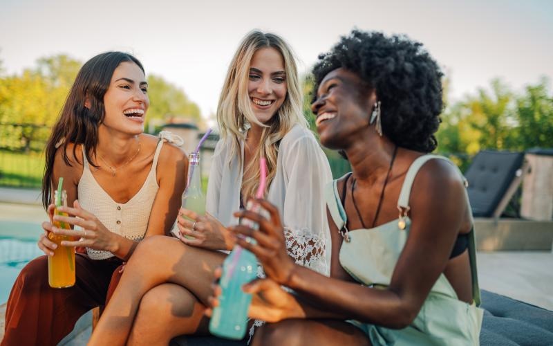 a group of women sitting on a bench and smiling