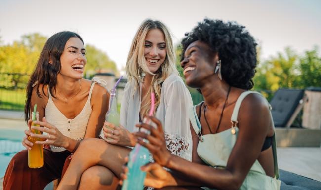 a group of women sitting on a bench and smiling