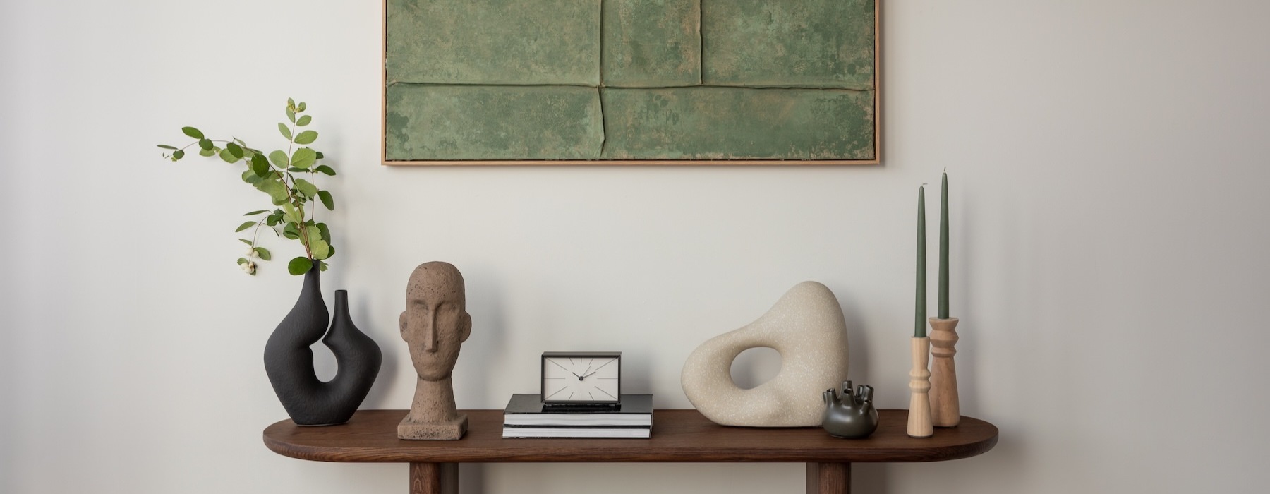 a table with a clock and a vase with flowers on it