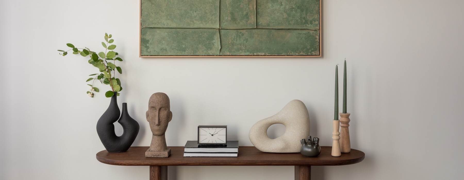 a table with a clock and a vase with flowers on it